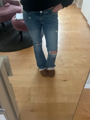 Ljusblå slitna bootcut jeans - Säljer ett par ljusblå bootcut jeans och slitningar på både fram- och baksida. Jeansen är från Gina men hålen är gjorda själv, jätte snygga och sköna❤️❤️ hör av er vid frågor❤️