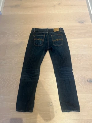 Nudie jeans Gritty Jackson  - Säljer ett par tvärfeta nudie jeans i modellen gritty Jackson.  Dem är i storlek 28/28. Modellen på bilden är 174 cm lång och väger 68 kg. Jeansen är anvönda men ändå i gott skick. Finns även en snus fade på bakre ficka. Nypris är 1600 mitt pris är endast 899.