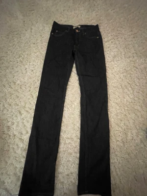 Mörkblå raka jeans från Acne - Säljer ett par mörkblå jeans från Acne med raka ben. Jeansen har kopparfärgade nitar och knapp, samt Acne-logga. De har används ett fåtal gånger. W28 L34