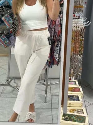 Vita mjukisbyxor med dragsko - Säljer ett par vita mjukisbyxor med avslappnad passform och resår i midjan samt dragsko för justerbar komfort. Byxorna har raka ben och sidofickor. Perfekta för en chill och bekväm stil. Materialet ser ut att vara mjukt och luftigt, troligen bomull eller bomullsblandning.