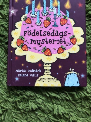 Födelsedagsmysteriet bok - En färgglad och illustrerad barnbok med titeln 'Födelsedagsmysteriet' av Martin Widmark och Helena Willis. Omslaget har en stor rosa tårta med ljus och jordgubbar mot en lila bakgrund. Perfekt för dig som gillar mysterier och spännande berättelser.