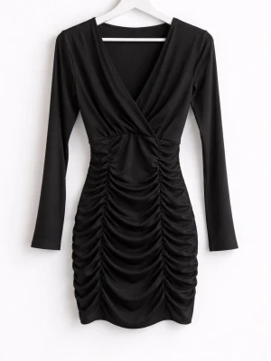 Svart omlottklänning med rynk - Snygg svart kortklänning med omlott framtill och långa ärmar. Klänningen har markerad midja och rynkade detaljer längs hela kjolen för en smickrande siluett. Perfekt för dig som gillar en stilren och trendig look.