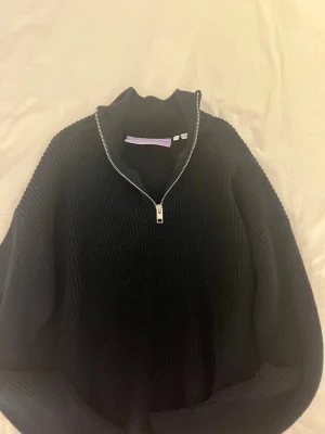 MarinBlå stickad tröja med dragkedja JJXX 💞 - Säljer en Marinblå stickad tröja från JJXX med hög krage och silverfärgad dragkedja framtill. Tröjan har ribbstickade detaljer på ärmar och kropp, vilket ger en snygg och modern look. Perfekt för lager på lager under kyliga dagar.