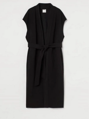 Lång väst/kappa med knytskärp - Svart ärmlös kappa från H&M, etiketten visar XS i storleken men den är oversize så skulle säga att den passar mer L-XL i storlek helt ny med lappar på