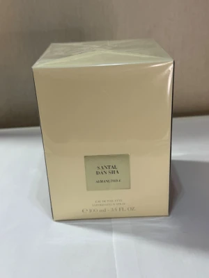 Armani Privé Santal Dan Sha 100ml - Exklusiv parfym från Armani Privé, Santal Dan Sha, i en stilren beige kartong med silverdetaljer. Flaskan rymmer 100 ml Eau de Toilette och har en lyxig känsla som passar dig som gillar eleganta dofter och snygg design.