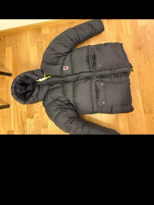 Fjällräven jacka  - Svart fjällräven jacka som är näst intill oanvänd. Säljer nu min jacka då den inte kom till användning. Har haft den hela vintern och använt den ett fåtal gånger så är i nyskick. De är den tjockare modellen på den och storlek XSS. Eftersom den är stor i modellen så passar den perfekt på mig som har S/M och blir inte för kort i armar eller liknande. 