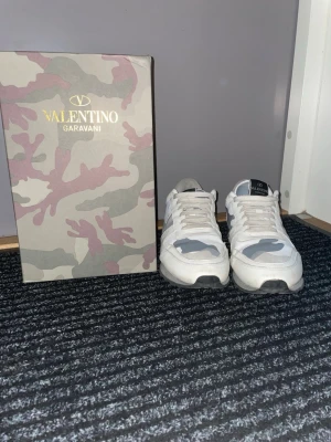Vita Valentino Garavani rockrunners  - Tja, säljer as feta valentino rockrunners med en väldigt fin samt unik färg (vit) som man inte ser alla andra ha. Använd väldigt försiktigt, och fått alltid komplimanger av dem. Skickar med boxen, skydd, och allting jag fick med skorna vid köp. Priset är ej hugget i sten! Tvättas innan leverans.