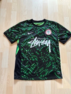 Nigeria x Stüssy Special Edition Kit - Stilren fotbollströja i helt nytt skick. Tröjan är inte använd en endaste sekund.