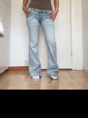 Ljusblå bootcut jeans  - Säljer ett par ljusblå bootcut jeans från weekday  . Jeansen har låg midja och är tillverkade i denim med lite stretch för skön passform. Kanppt anvönda storlek 27/32 men jag brukar använda 25/32. 