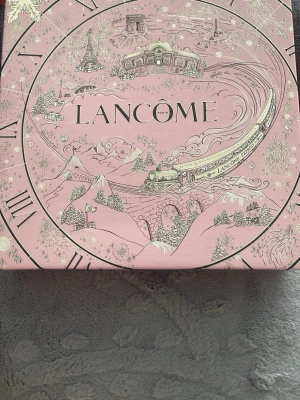 Lancôme La Vie Est Belle presentbox - Säljer en lyxig presentbox från Lancôme med parfymen La Vie Est Belle. Boxen är rosa med vackra illustrationer och innehåller en Eau de Parfum i glasflaska med silverdetaljer samt en matchande body lotion. Perfekt för dig som älskar eleganta och feminina dofter.