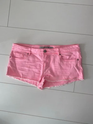 Rosa lågmidjade jeansshorts - Lågmidjade korta jeansshorts i rosa. Knappt använda.