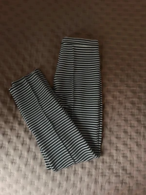 Randiga byxor från By Malene Birger - Snygga svartvita byxor från By Malene Birger med horisontella ränder. De har en elastisk midja och är tillverkade i ett stretchigt material som sitter tajt och bekvämt. Perfekta för en trendig och avslappnad stil. Aldrig använda och normala i storleken😊