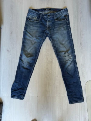 Blå slim replay anbass - Säljer ett par blå slim fit jeans från replay med slitningar och snygg tvätt. Storleken är W 34 L 33 ,men sitter mer som W 33. Har lappat det största hålet vid knät på insidan, vid funderingar hör gärna av dig 🙌