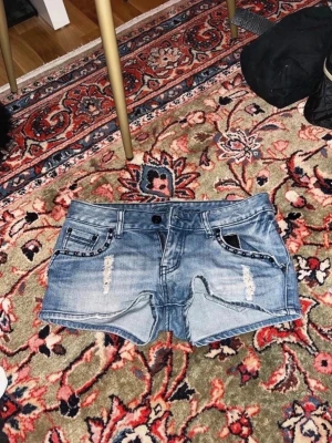 Blå denimshorts med slitningar - Midjemått: 37cm 