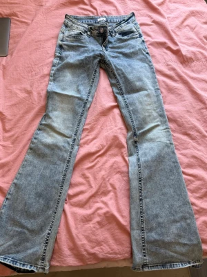 Bootcut jeans från Missay! - Snygga ljusblå bootcut jeans från Missay med klassisk femficksdesign och låg midja. Jeansen har slitningar och en cool tvätt som ger en avslappnad vibe. Jag har sprättat upp dom längst ner så passar dig som är typ 170cm!