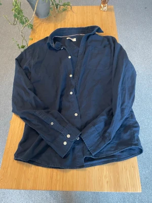 Mörkblå linneskjorta Jack & Jones - Säljer min sköna mörkblå skjorta från Jack & Jones i mjukt linnematerial. Storlek M i regular fit, skriv vid frågor!🥂 (väldigt bra skick)