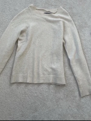 Beige stickad tröja - En stilren beige stickad tröja. Tröjan är fin och enkel att matcha med olika outfits.