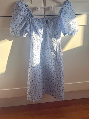 Blommig klänning med puffärm - Söt ljusblå klänning med puffiga ärmar. Använd fåtal gånger. Pris kan diskuteras💕