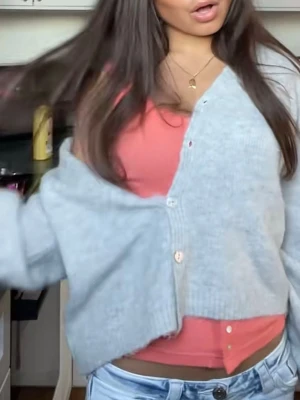 Ljusgrå fluffig kofta - Supermjuk och fluffig ljusgrå kofta från gina med v-ringning och knappar framtill. Koftan har en avslappnad passform, långa ärmar. Perfekt att slänga över en topp för en chill look. Använd max 1 gång