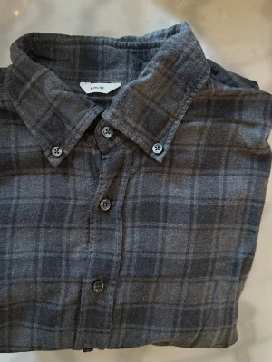 Slimline flanellskjorta – mörkgrå rutig, strl 40 / M - Stilren mörkgrå rutig skjorta från Stenströms i Slimline-passform (slimmad). Mjuk flanell i premium bomull.  • Storlek 40 / M • Slim fit • Mörkgrå rutig • Button-down krage • Mycket fint skick  Material: Mjuk bomullsflanell  Nypris ca 1 500–1 700 kr  En riktigt snygg och användbar skjorta som funkar till allt.  