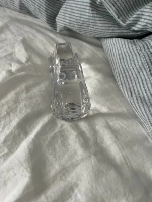 Glasbil från Kosta Boda - Säljer en dekorativ glasbil från Kosta Boda. Bilen är helt genomskinlig och har en stilren, minimalistisk design. Perfekt som prydnad eller samlarobjekt för dig som gillar unika inredningsdetaljer.
