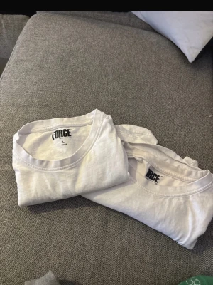 Vita FORCE t-shirts i bomull - Två klassiska vita t-shirts från FORCE i storlek L. T-shirtsen har rund hals, korta ärmar och är gjorda i mjuk bomull. Perfekta för en clean och enkel stil, lätta att matcha med allt.