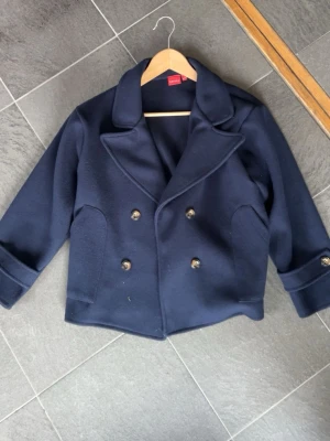 Marinblå kappa - Marinblå kappa från RYVLS. Andvänd ett fåtal gånger och väldigt bra skick. Skriv för fler bilder.