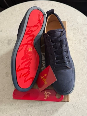 Christian Louboutin  - Snygga blåa sneakers från Christian Louboutin med klassisk röd sula och diskret logga. Skorna har en låg profil, är gjorda i mocka och har matchande blåa skosnören. Perfekt för dig som vill ha något exklusivt och stilrent. Denna är köpt för 4900kr, säljer för att de inte passar, passa på!