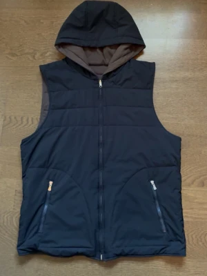 Vändbar väst från Gran Sasso - Jävligt schysst vändbar väst från gran sasso med luva. Västen är väldigt lätt och enkel att matcha med. Plagget är köpt på Zgander i Helsingborg för ett nypris på 4000kr, lapparna är inte kvar men västen är i mycket fint skick och knappt använd. Västen är riktigt stilig och unik!