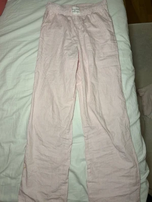 Pyjamasbyxor från Kappahl - Det är ett par fina ljusrosa pyjamasbyxor med vita ränder, jag säljer dem för att dom har tyvär nlivit för korta. Priset kan diskuteras! Det är en liten fläck längs ner på byxan.