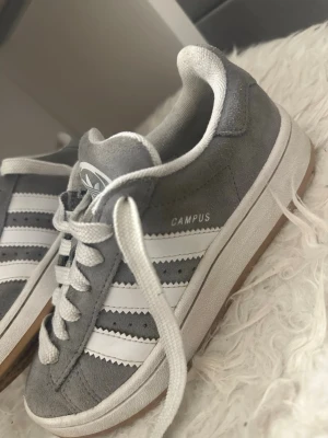 Gråa Adidas campus  - Gråa adidas campus skor i storlek 35 1/2 men skulle säga att dom passar någon som har storlek 36 också.