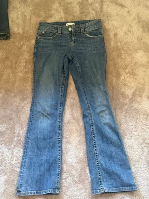 Blå bootcut jeans från Gina - Säljer ett par klassiska blå bootcut jeans från Gina, strl 36 i petite