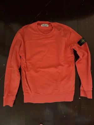 Sweatshirt från Stone Island - Säljer en sweatshirt från Stone Island med klassisk rund halsringning och ribbade muddar. Tröjan har den ikoniska Stone Island-loggan på vänster ärm och är tillverkad i mjukt bomullsmaterial.