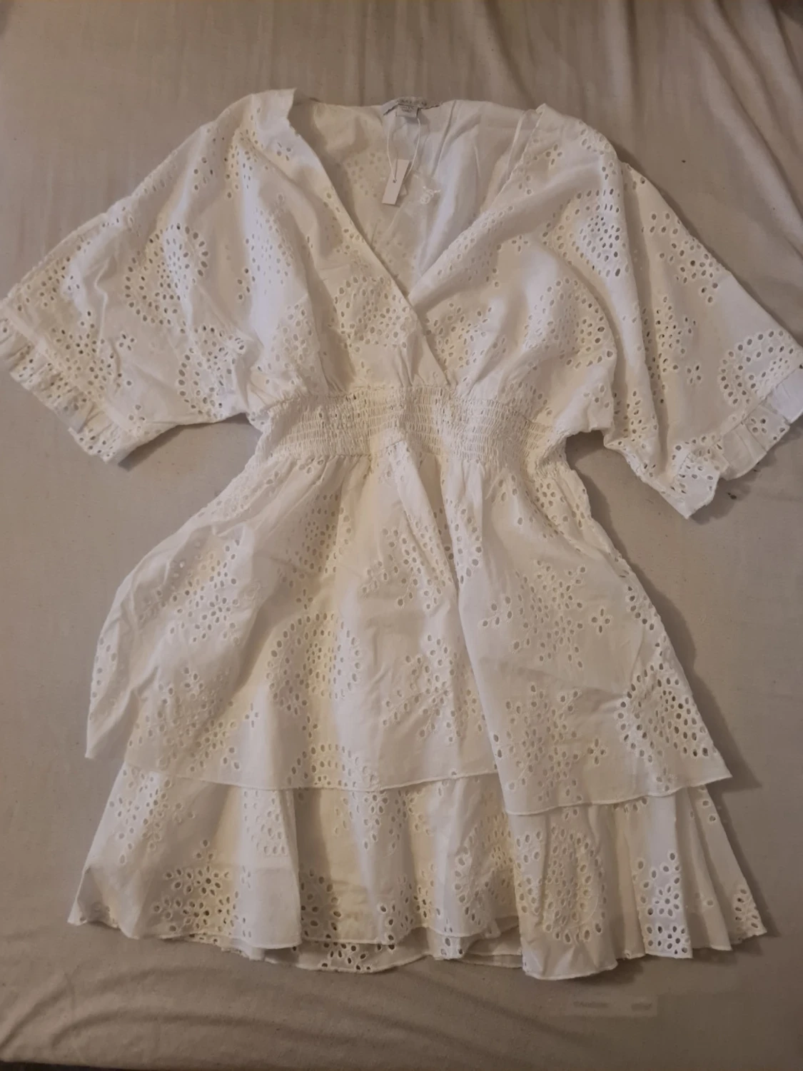 Vit omlottklänning med broderade detaljer