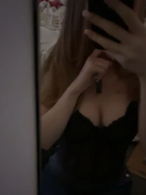 Svart spetsbody med djup urringning - Säljer en svart body i spets med djup urringning och tunna axelband. Bodyn har en feminin och elegant design med transparenta detaljer. Perfekt för dig som vill ha något snyggt och stilrent under kläderna.