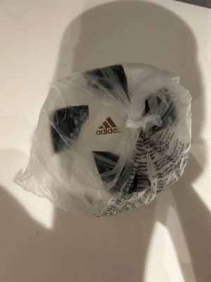 Adidas Telstar 18 fotboll - Säljer en Adidas Telstar 18 fotboll i vitt med svart och grått pixelmönster samt gulddetaljer. Bollen har klassisk rund form och är tillverkad i slitstarkt syntetmaterial. Det är vem bollen från 2018 och helt ny. Oanvänd, har inte ens pumpat upp den?
