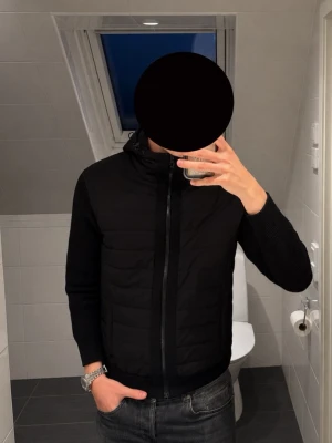 Gran Sasso Hybrid Cardigan Jacka Svart - Snygg och stilren hybrid cardigan/jacka från Gran Sasso i svart. Perfekt som ett lite schysstare lager under vår, höst eller svalare sommarkvällar. Väldigt fin kvalitet och i mycket fint skick.
