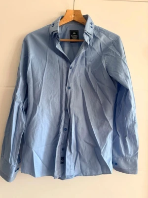 👔 Elegant herrskjorta – blå, storlek M - 👔 Elegant herrskjorta – blå, storlek M  Säljer en snygg herrskjorta i blå färg 💙 Perfekt till vardags, jobbet eller mer formella tillfällen ✨  📏 Storlek: M 📐 Mått: – Bredd: 104 cm – Längd: 68 cm  🧵 Material: – 60% bomull – 40% polyester  Skjortan är bekväm, sitter snyggt 👍 och är lätt att sköta tack vare polyesterblandningen.  📩 Hör gärna av dig vid frågor 😊