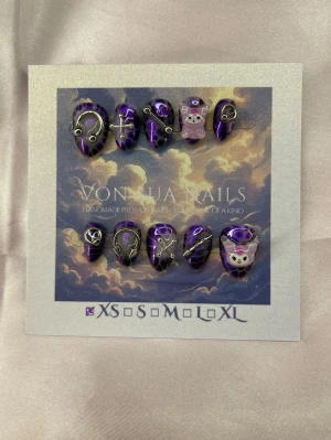 PurpleKuromi (XS);ExtraShortAlmond  - Unika handgjorda press-on naglar i lila och svart med Kuromi, silverdetaljer. Två naglar har Kuromi-motiv i rosa och vitt. Formen är extra kort almond och är XS: 14 mm, 11 mm, 11,5 mm, 10 mm, 8 mm. Perfekt för dig som vill sticka ut med en edgy och söt look.