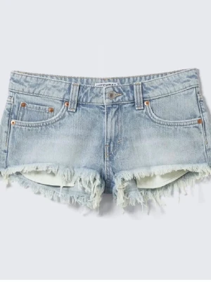 Blå jeansshorts Weekday stl W26 - Säljer ett par ljusblå jeansshorts från Weekday med råa, fransiga kanter och klassisk femficksdesign. Shortsen har bälteshällor och knappgylf. Perfekta för sommaren och ger en avslappnad vibe.