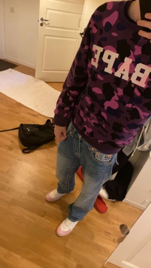 BAPE SWEATSHIRT - ÄKTA OCH GRANSKAD THRIFTAD FRÅN SYDKOREA KÖPT FÖR 2200 då denna är väldigt sällsynt. Säljer en lila och svart camo sweatshirt från BAPE med stor vit logga på bröstet. Tröjan had XXL men ja är 190 o den passar som på bilden så vill du ha en liten skön loose fit äre ba köra på . går ner i pris vid smidig affär