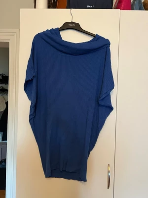 Blå stickad tröja från Noppies - Snygg blå stickad tröja från Noppies med lös passform och bred krage. Tröjan har ribbad struktur och är perfekt för dig som gillar en avslappnad och trendig stil. Passar bra till jeans eller leggings.