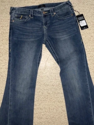 True Religion jeans - Snygga Low Waist bootcut jeans från True Religion med klassiska kontrastsömmar och detaljerad bakficka i nyskick med prislapp i modellen Joey!💗I strl W29 som motsvarar ungefär S! Skulle säga att jeansen är små i storleken! Nypris 1399 kr men säljer för 680 kr då jag bara vill ha sålt, och har även väldigt många True Religion jeans i samma modell därav säljer jag💗