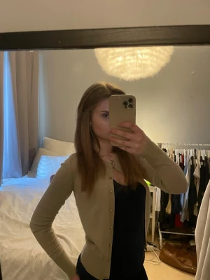 Beige kofta med knappar - Snygg beige kofta med smal passform och knäppning framtill. Perfekt att bära över ett linne eller t-shirt. Enkel och stilren design som passar till det mesta.