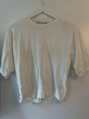 Vit basic t-shirt från Lager 157 - En enkel vit t-shirt från Shein med rund hals och breda ärmar och tajtare runt magen. Perfekt för att matcha med jeans eller shorts. Materialet är mjukt och känns skönt mot huden, tillverkad i bomull. Klassisk passform som funkar till många olika stilar.