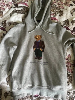 Ralph Lauren Hoodie - Polo Bear  - Säljer denna grå polo bear hoodien is storlek s eftersom jag knappt använder den längre. Fortfarande i väldigt bra skick. Skriv vid intresse! 