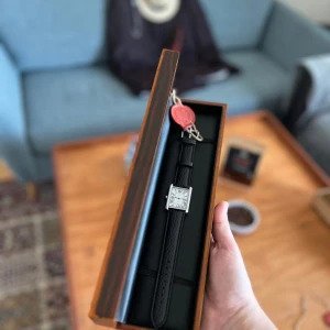 Först till kvarn - helt Oanvänd Cosmos d'Heritage rektangulär klocka med svart läderband - ✅ Specifikationer: 	•	Glas: Härdat glas 	•	Armband: Äkta läder 	•	Spänne: Rostfritt stål 	•	Vattentålighet: 1 ATM  ✨ Höjdpunkter:	Material: Zinklegering 	•	Bandbredd: 20mm 	•	Skickas i en premium träbox – perfekt som gåva 	•	Pris: Endast 449 SEK! Köpte för 1200 från deras hemsida