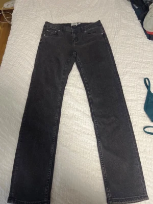 Svarta raka jeans från 157 - Säljer ett par svarta raka jeans från 157. Klassisk femficksmodell med normal passform och knappgylf. Perfekta till en avslappnad stil och funkar året runt. Materialet är tåligt jeans och färgen är mörk svart.