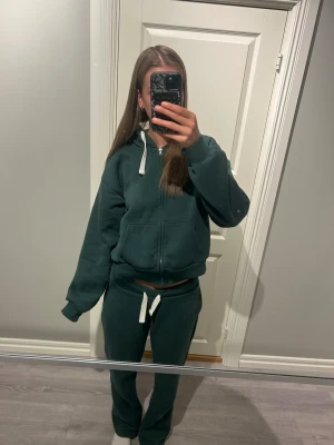 Grönt mjukis set - Säljer detta mjukis set då jag aldrig använder!            Storlek zip hoodie: L (Gina 14+)                                     Storlek byxor: M (Gina 14+) OBS! Inga bakfickor finns!