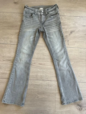 Grå Jeans - Ett par snygga grå jeans med bootcut och låg midja som är i storlek 158. De är använda ett fåtal gånger och är som nya! Det finns inga tecken på användning. 